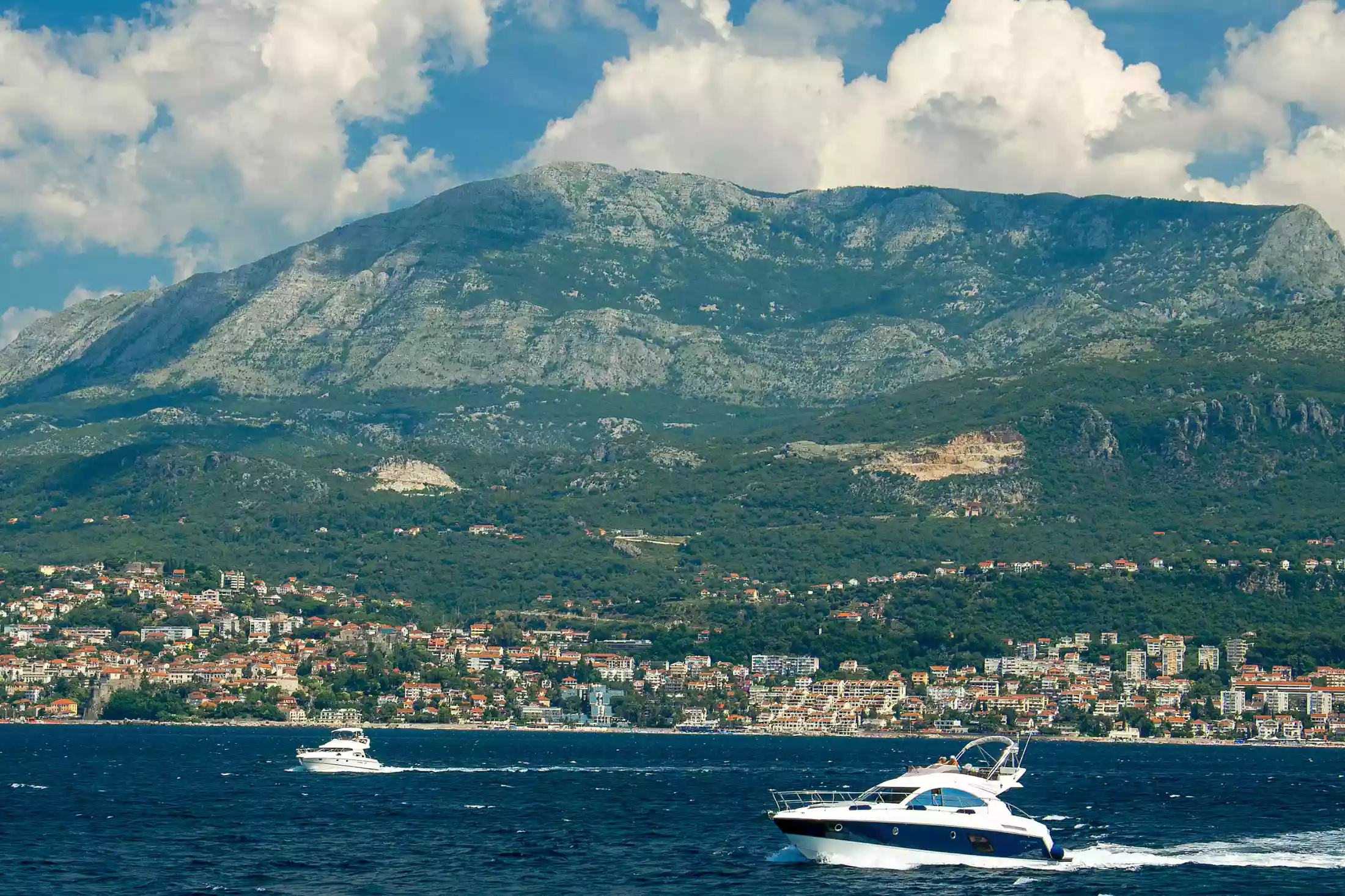 : The sparkling Adriatic Sea and quaint Herceg Novi town cradled at the foot of the towering Mount Orjen.